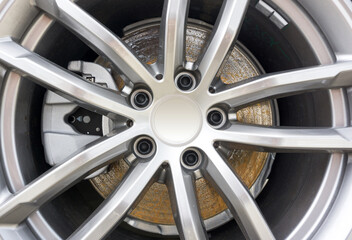 Close up of rust on the vehicle's disc brake with caliper on background.