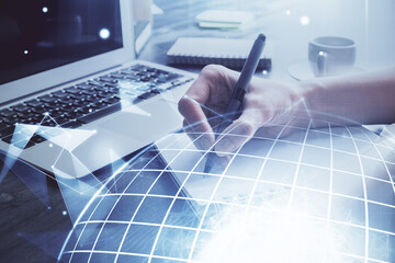 Double exposure of hands making notes with world map hologram and data theme icons. Concept of global computer data.