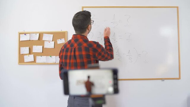 Young Male Math Teacher explaining hard math equation in online class, talking to camera
