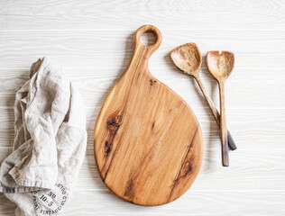 Kitchen cooking flat lay. Wood spoons and wood cutting board for placing your text on light wood...