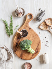 Kitchen cooking flat lay. Various food ingredients, kitchen utensils and wood cutting board on light wood board background. Top view.