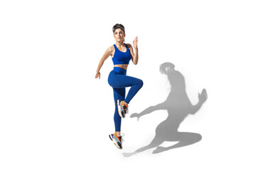 Fototapeta na wymiar Movement. Beautiful young female athlete practicing on white studio background, portrait with shadows. Sportive fit model in motion and action. Body building, healthy lifestyle, style concept.