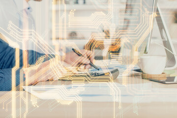 Technology theme hologram with man working on computer on background. High tech concept. Multi exposure.