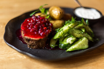 Grilled potatoes and steak with cucumbers