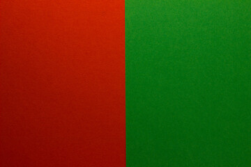Fototapeta premium Background of two vertical rectangles red and green. Sheets of blank red and green paper with fine texture, split vertically, close up.