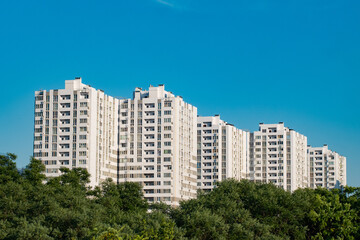 Fototapeta na wymiar Urban landscape with white skylines and green trees 