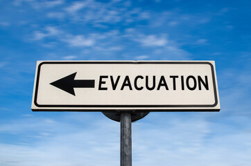 Fototapeta premium Evacuation road sign, arrow on blue sky background. One way blank road sign with copy space. Arrow on a pole pointing in one direction.