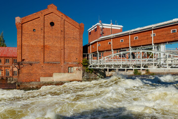 Kouvola, Finland - 15 September 2020: Old red brick buildings of Upm factory on rapids Kuusankoski.