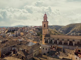 Obraz premium Aerial image ancient architecture view of Bocairent against hills and cloudy sky background. Valencian Community, Spain