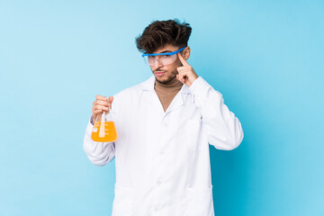 Young arab scientific man isolated pointing temple with finger, thinking, focused on a task.