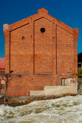 Kouvola, Finland - 15 September 2020: Old red brick buildings of Upm factory on rapids Kuusankoski.