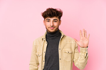 Young arabian man posing in a background isolated smiling cheerful showing number five with fingers.