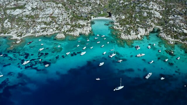Bird Eye View over Cala Serena at Caprera Island, Sardinia. Flying High Bay Full of Boats and Luxury Yachts. Cristal Clear Turquoise Water. Rocky Coastline.