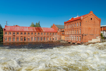 Kouvola, Finland - 15 September 2020: Old red brick buildings of Upm factory on rapids Kuusankoski.