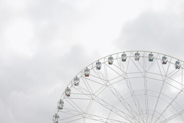 Fototapeta premium ferris wheel on a cloudy day, grey color background