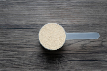 Whey protein powder with measuring Scoop, sports bodybuilding supplement.
