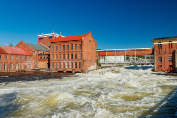 Kouvola, Finland - 15 September 2020: Old red brick buildings of Upm factory on rapids Kuusankoski.