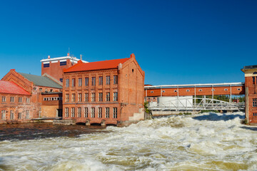 Kouvola, Finland - 15 September 2020: Old red brick buildings of Upm factory on rapids Kuusankoski.
