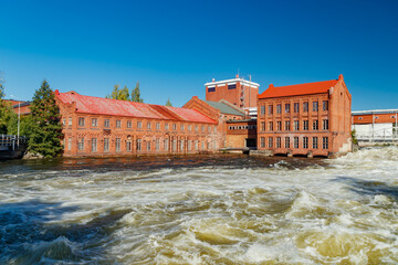 Kouvola, Finland - 15 September 2020: Old red brick buildings of Upm factory on rapids Kuusankoski.