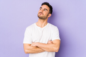 Young caucasian man isolated on purple background dreaming of achieving goals and purposes