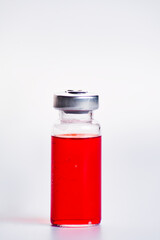 Medicine red vial with solution for injection on white background