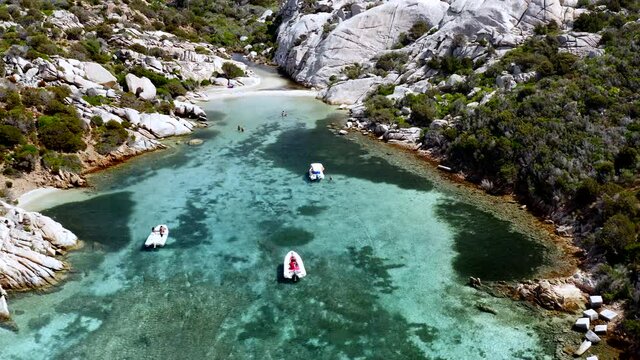 Flying Away from Small Private Cala at Caprera Island, Sardinia, Italy.
Unveiling Tiny Beach. Aerial Drone View. Rocky Coastline. Turquoise Cristal Clear Sea.