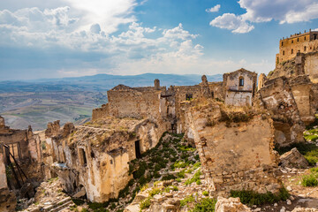 Fototapeta na wymiar Craco, Matera, Basilicata, Italy. The ghost town destroyed and abandoned following a landslide. The collapsed houses and the remains invaded by vegetation, stones and debris. Broken doors and windows.