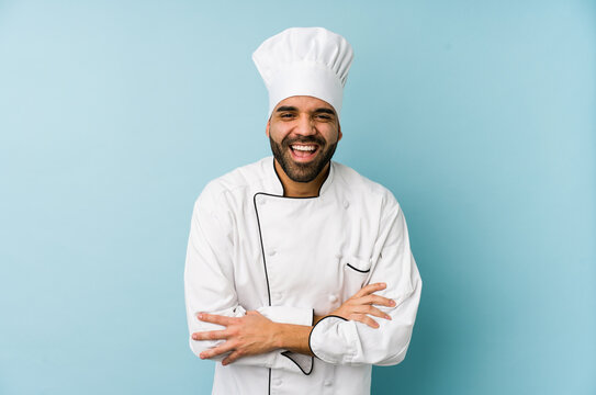 Young latin chef man isolated laughing and having fun.
