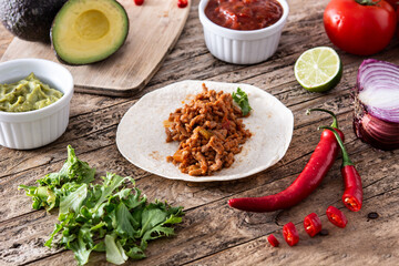 Mexican tacos ingredients on wooden table	
