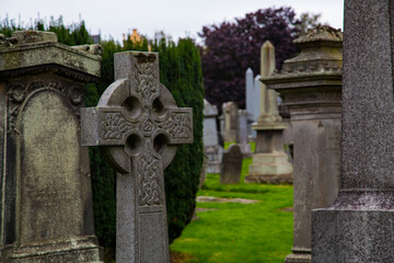 Lápida de cruz celta adornado con deterioro y lápidas de fondo