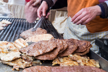 Traditional serbian street food (rostilj) - pljeskavica, cevapi, grilled chicken breast, bbq chicken wings and homemade sausages served with fresh bakery (lepinja)