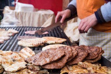 Traditional serbian street food (rostilj) - pljeskavica, cevapi, grilled chicken breast, bbq chicken wings and homemade sausages served with fresh bakery (lepinja)