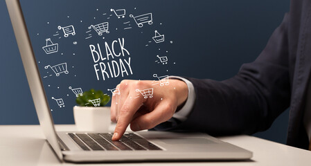 Businessman working on laptop with BLACK FRIDAY inscription, online shopping concept