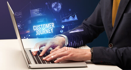 Businessman working on laptop with CUSTOMER JOURNEY inscription, new business concept