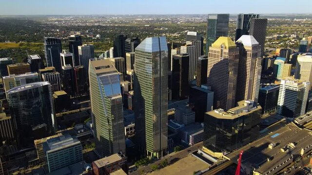 Aerial view around highrise buildings in downtown Calgary city, on a sunny evening, in Alberta, Canada - Orbit, drone shot