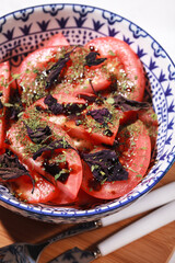 Salad with tomatoes and Basil. Fresh vegetables in a blue plate. Vegetable and vegetarian salad
