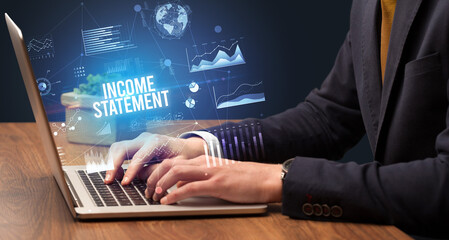 Businessman working on laptop with INCOME STATEMENT inscription, new business concept