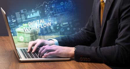 Businessman working on laptop with DIGITAL WORKFLOW inscription, cyber technology concept