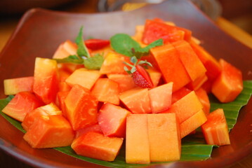 fresh papaya fruit slices decorated with mint leaves