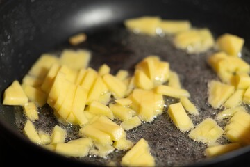The potatoes are cooked in a pan. Boiling potatoes in oil