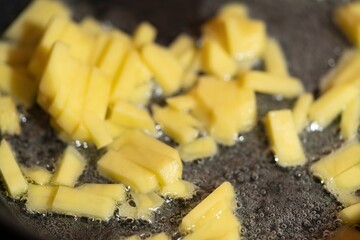 The potatoes are cooked in a pan. Boiling potatoes in oil