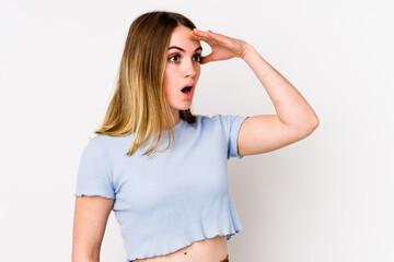 Young caucasian woman isolated on white background looking far away keeping hand on forehead.