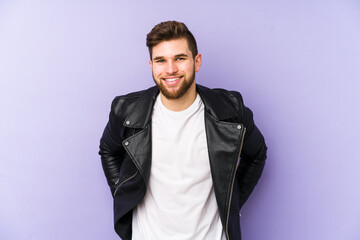 Young man isolated on purple background happy, smiling and cheerful.