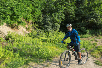 Obraz premium A male mountain biker on a forest trail