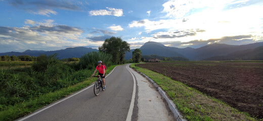 woman biking in a road with nice landscape