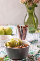 Oatmeal porridge with pears. Chia and pear for Breakfast. Beautiful and healthy Breakfast on a light background with a flower