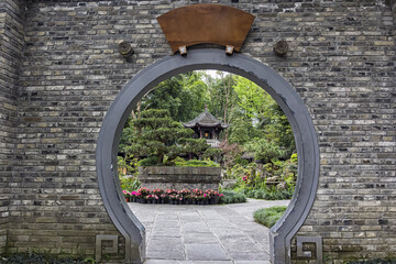 CHEMGDU, CHINA - Mar 23, 2019: Traditional Chinese round door in stone brick wall, entrance to a...