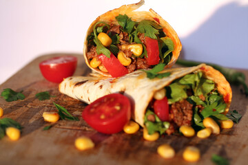 Tortilla wraps sandwiches with fresh vegetables, minced meat and on marble background. Burrito, sandwich wrap, fajita wrap