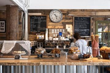 Anonymous barista preparing coffee in cozy bakery with fresh pastries