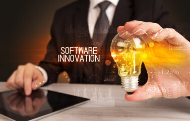 Businessman holding lightbulb with SOFTWARE INNOVATION inscription, Business technology concept
